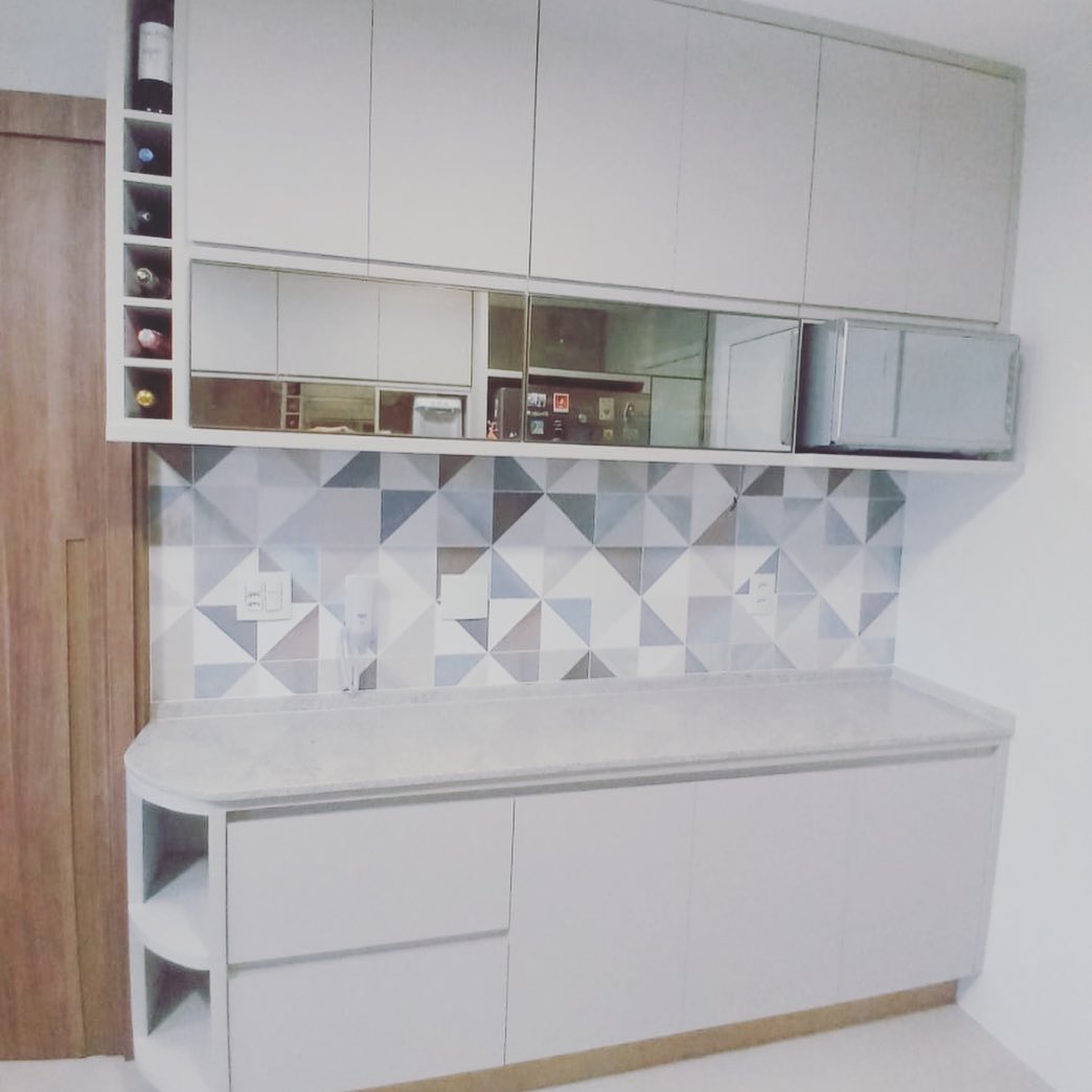 Estante branca com nichos, adega de madeira e balcão de apoio na sala de jantar